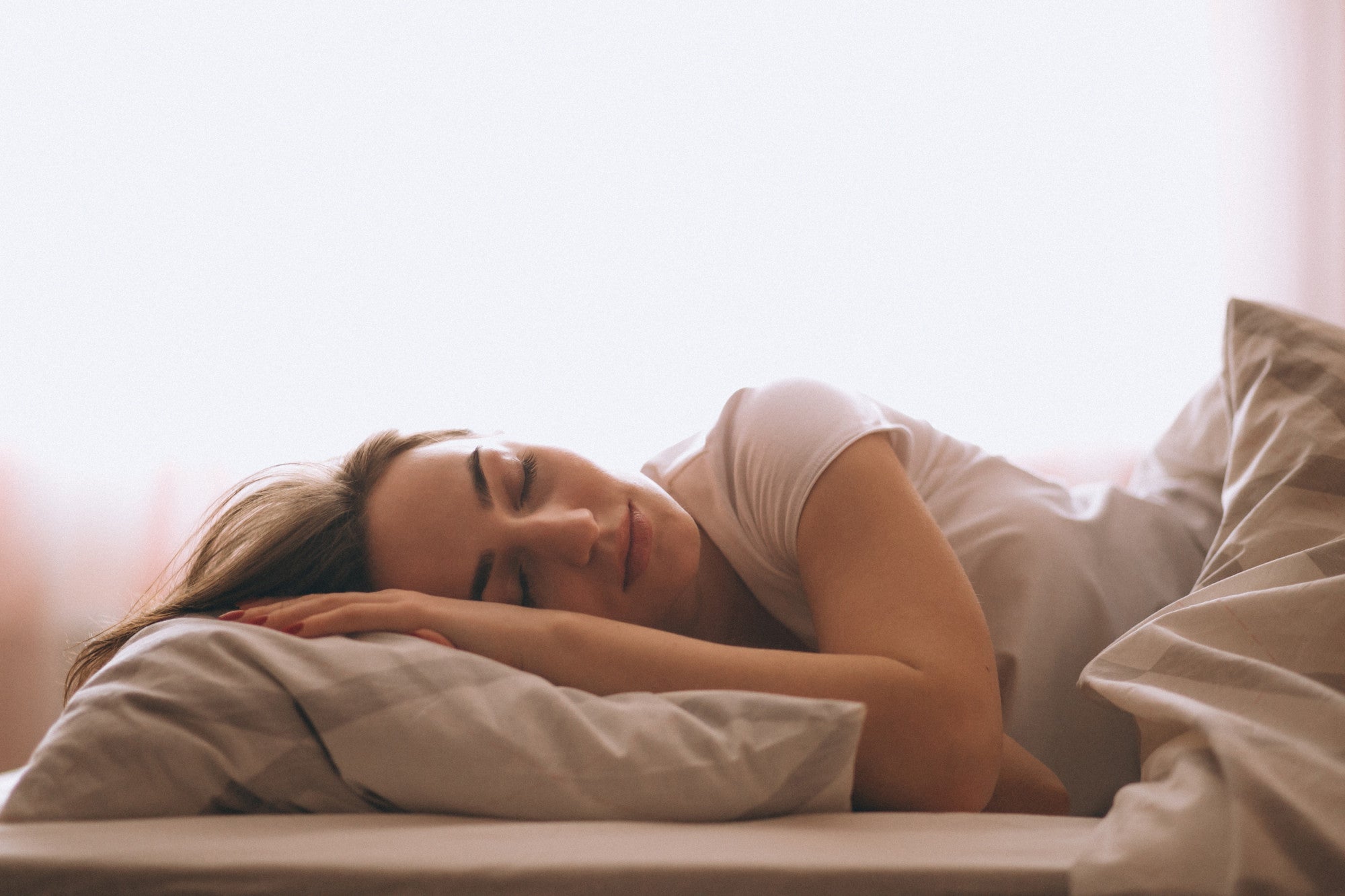 Eine tief schlafende Frau in einem gemütlichen Bett.