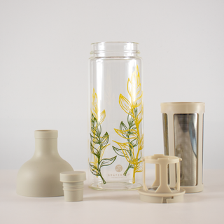 Die Einzelteile unserer Eistee Flasche "Clara": Eine stylische Glasflasche, ein Edelstahl Sieb, der Filterkopf für das Sieb und der Deckel mit Steckverschluss.